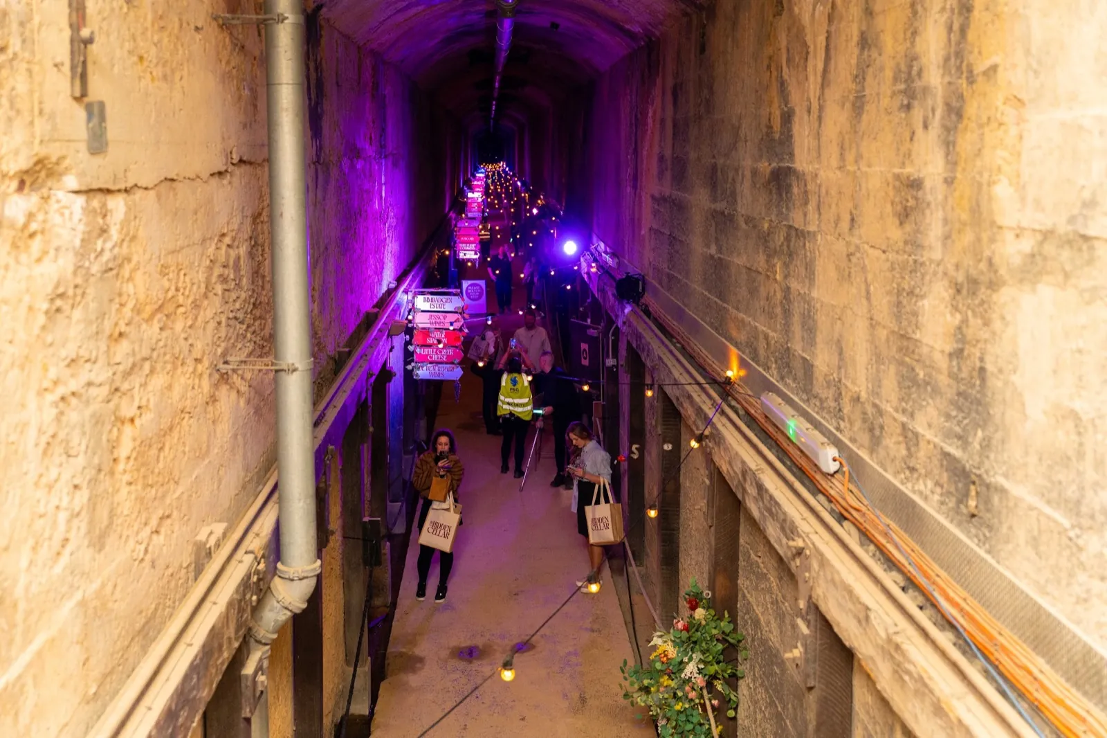 Guests walking through the lit-up tunnel at an Arclight event